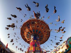 Ein farbenfreudiges Karussell in der Nähe des Marias Platzl Hotel in München dreht sich und schwingt viele Fahrgäste durch die Luft