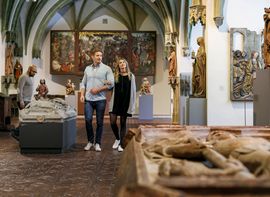 Bayrisches Nationalmuseum Ein Paar und ein anderer Besucher betrachten die Ausstellungsstücke im Bayerischen Nationalmuseum.