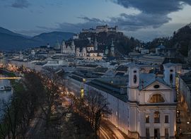 Nächtlicher Blick auf die Salzburger Altstadt mit dem Fluss Salzach und der Festung Hohensalzburg.
