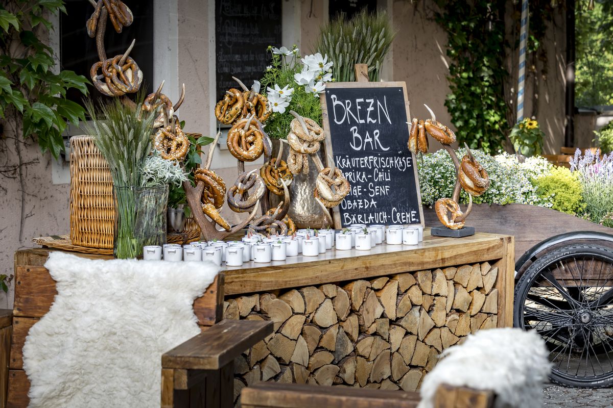 Breznbar auf Holzbuffet mit verschiedenen Brezen auf Geweihen gemeinsam mit kleinen weißen Töpfchen